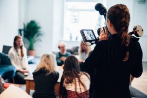 A young woman filming an interview. 