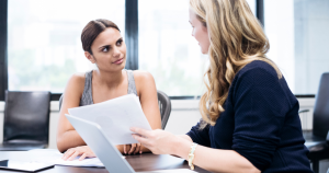 Young woman talking to professional over a paper.