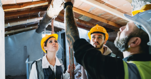 Young construction workers being mentored by older construction worker.